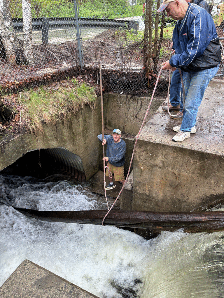 Volunteers getting a large log off the dam